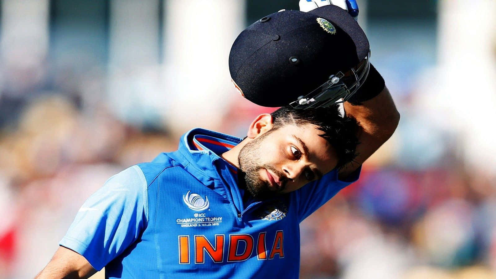 Virat Kohli 桌布 壁紙 — 印度板球隊隊長維拉·高利身穿藍色隊服，在比賽中舉起頭盔做出勝利姿態。