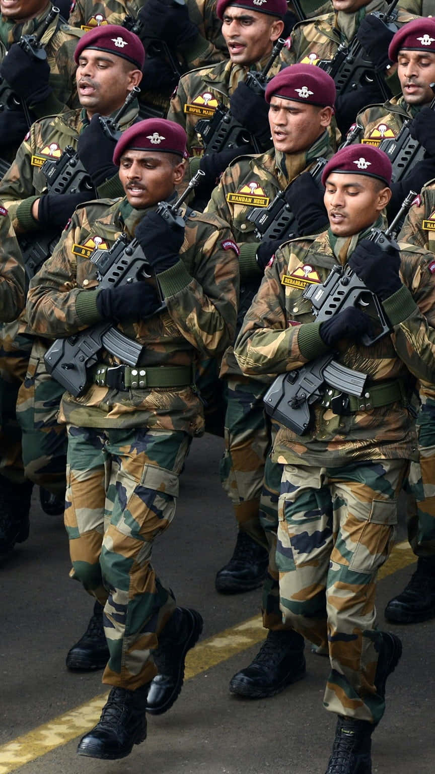 印度的榮耀與勇氣——印度陸軍 壁紙 — 身穿迷彩制服和栗色貝雷帽的士兵在閱兵期間持步槍列隊行進。