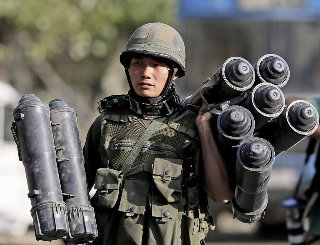 士兵在白天戶外穿著軍事裝備攜帶火箭發射器。
