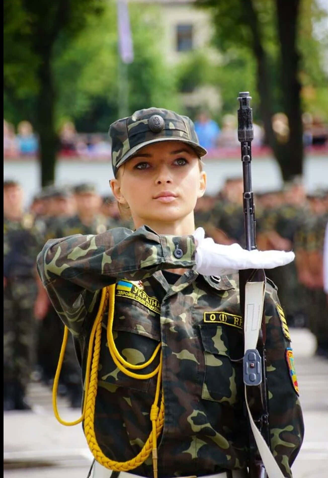 烏克蘭女兵身穿迷彩服，手持步槍在戶外立正。