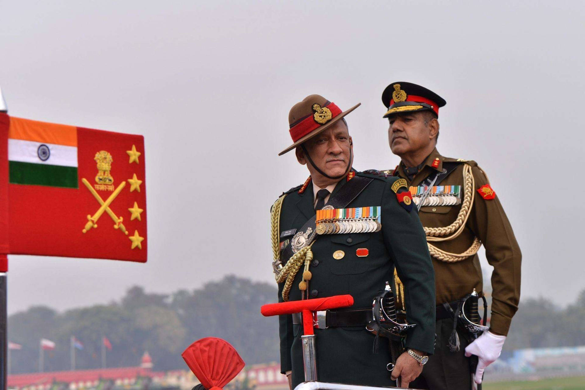 兩名印度軍官身穿禮儀制服，站在國旗旁立正。