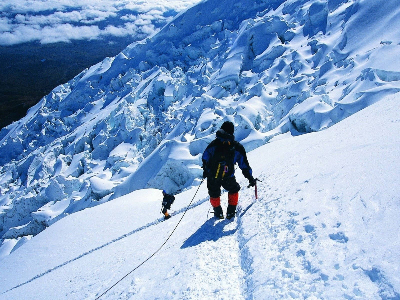 兩名攀岩者在崎嶇的冰層上行走於積雪冰川。