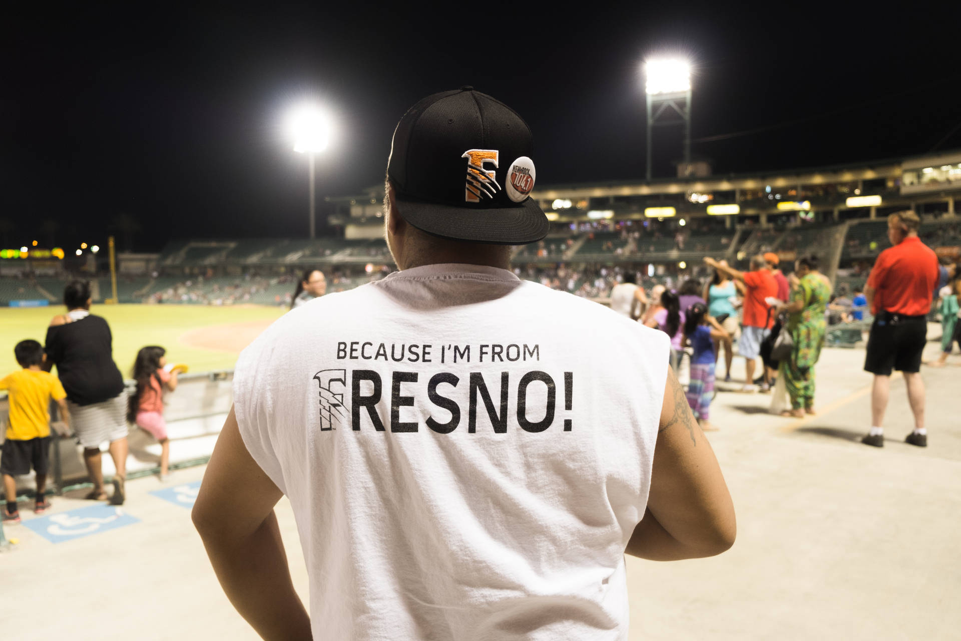 男子穿著 Fresno 驕傲襯衫參加夜間棒球比賽。