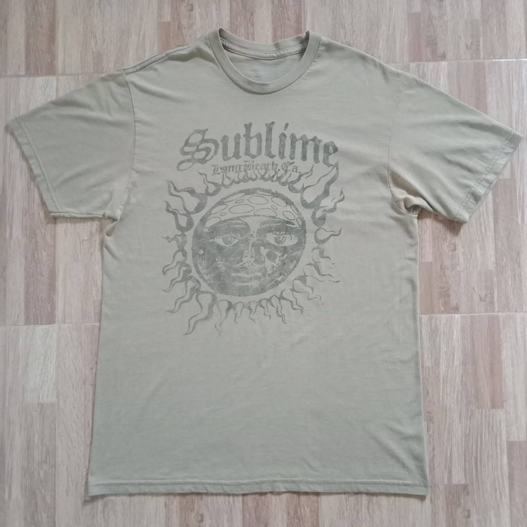 淺色木地板上的橄欖綠色 Sublime 樂隊 T 恤