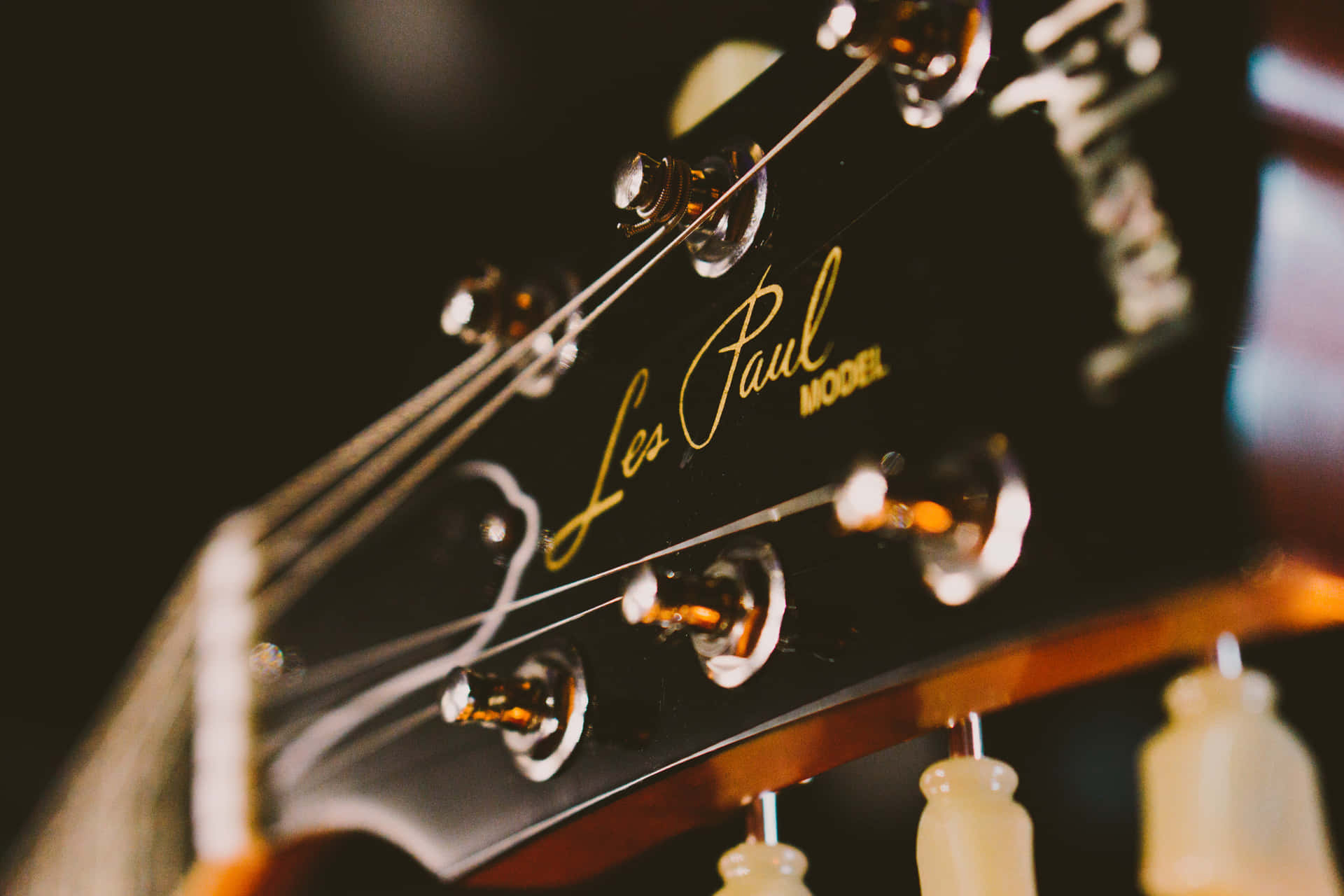 Les Paul結他琴頭特寫，金色字體和閃亮調音栓。