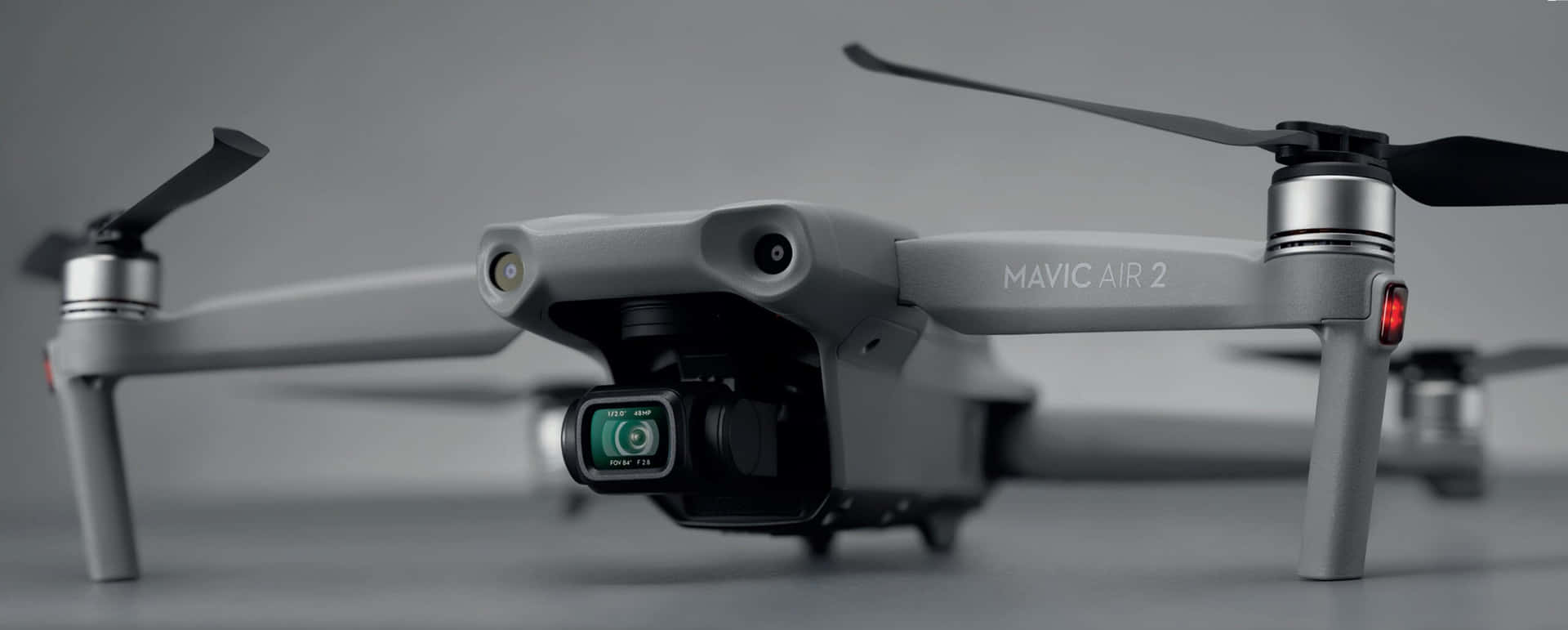 灰色DJI Mavic Air 2無人機的特寫，帶有黑色螺旋槳和綠色鏡頭。