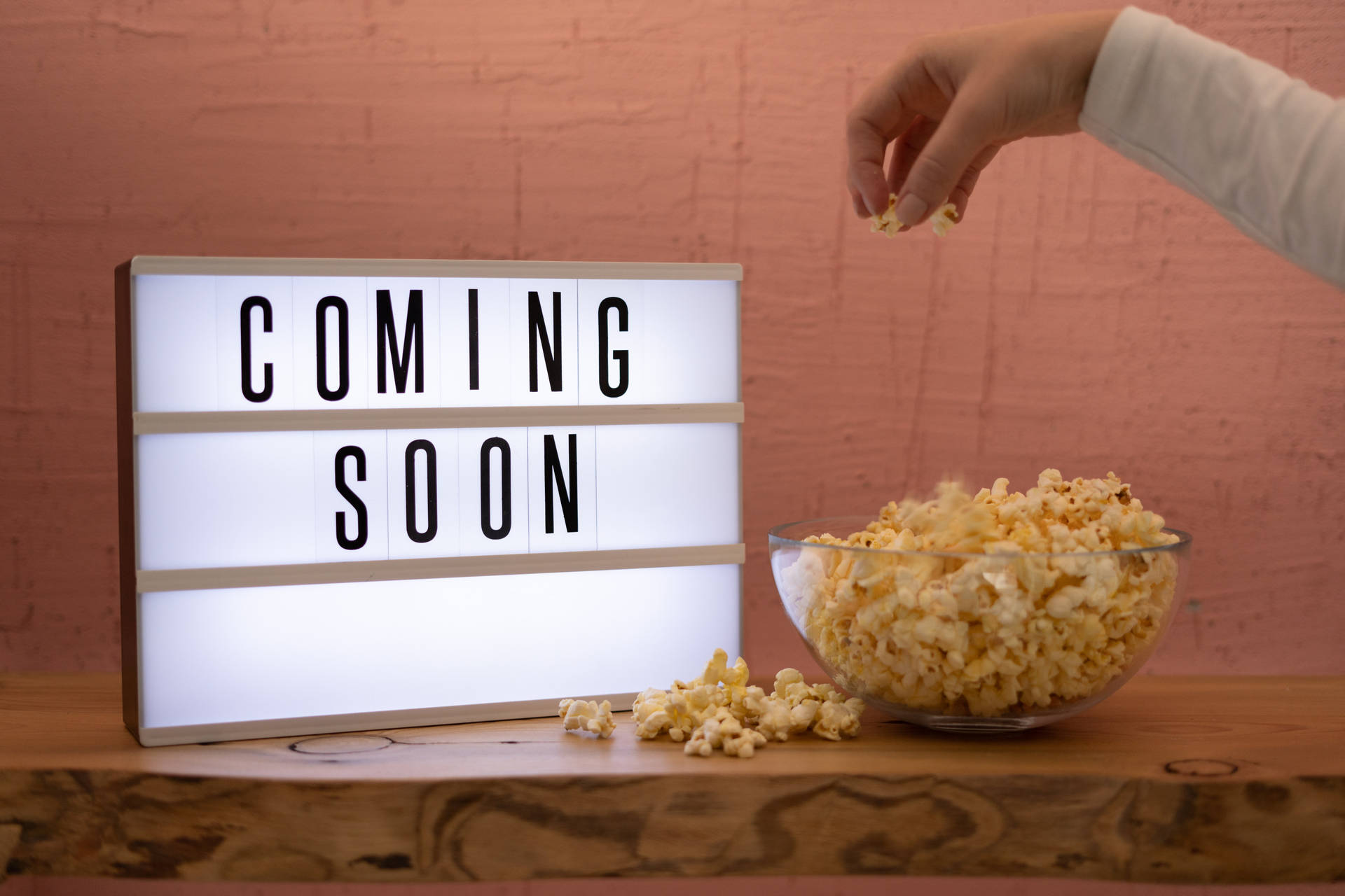 手在「Coming Soon」標誌附近抓取爆谷。