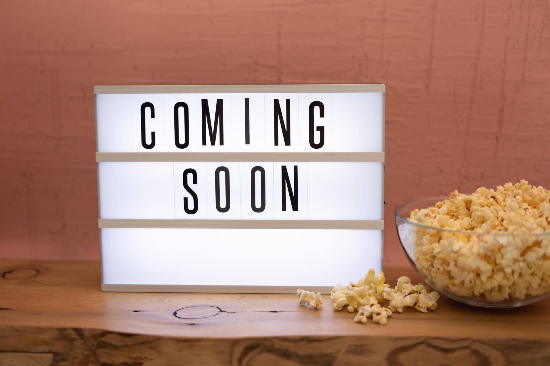 燈箱寫著 COMING SOON，旁邊是木上的爆谷碗。