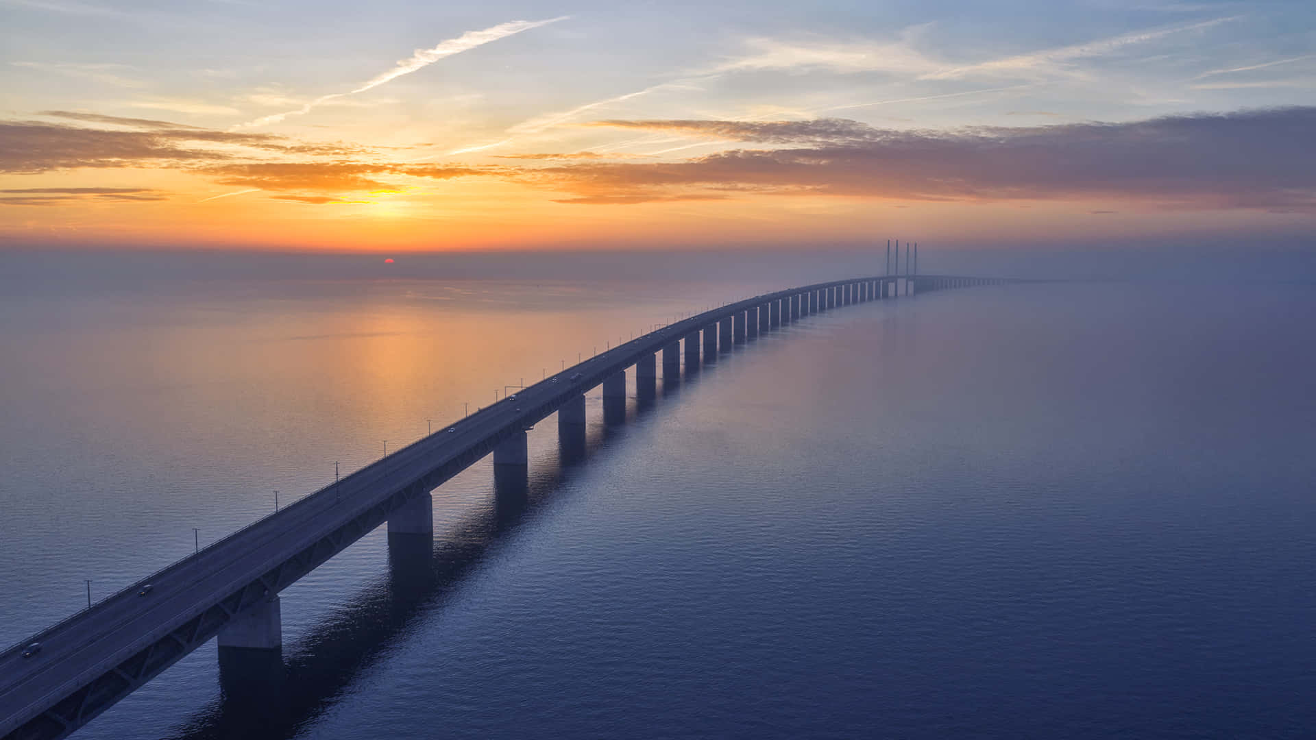 日落時分海上的長橋，橙色和藍色的天空