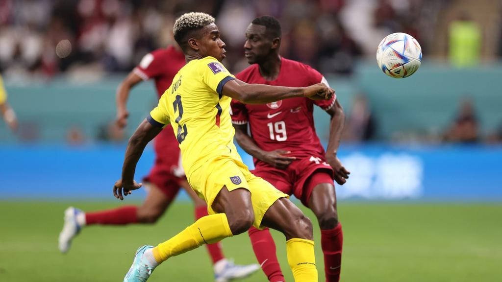 厄瓜多爾國家足球隊FIFA資格賽 壁紙 — 一名身穿黃色球衣的足球員跳起頂球，而一名身穿紅色球衣的後衛在球場上挑戰。