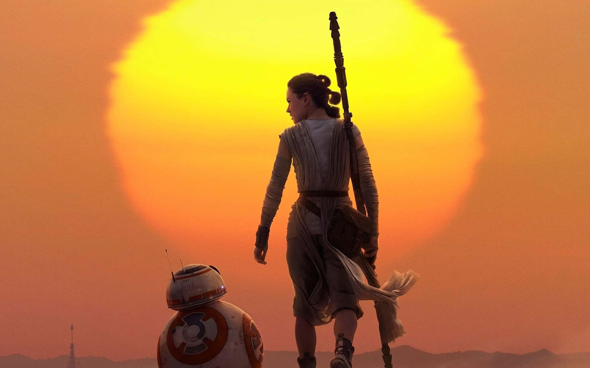Rey 和 BB-8 在夕陽下的沙漠中行走，身後有一個巨大的太陽。