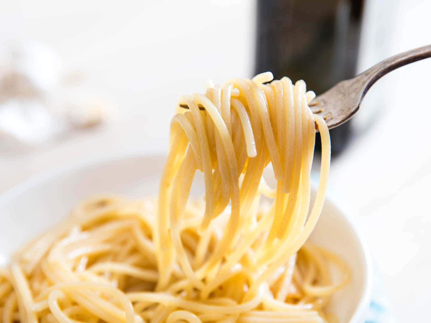 Noodles 桌布 壁紙 — 叉子從白色碗中提起光澤的意大利麵條，背景柔和模糊。