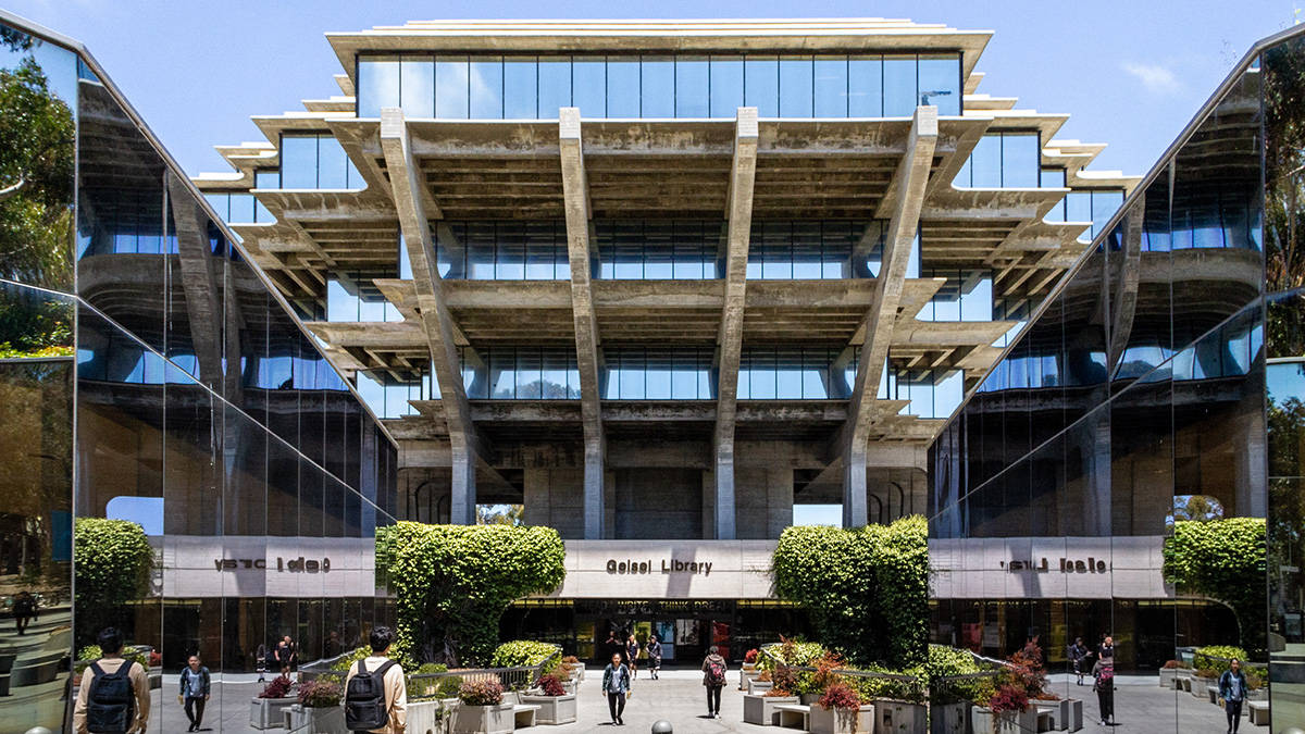 反射玻璃UCSD 壁紙 — 現代混凝土和玻璃圖書館建築，設有分層陽台和反射表面，在明亮的藍天下。