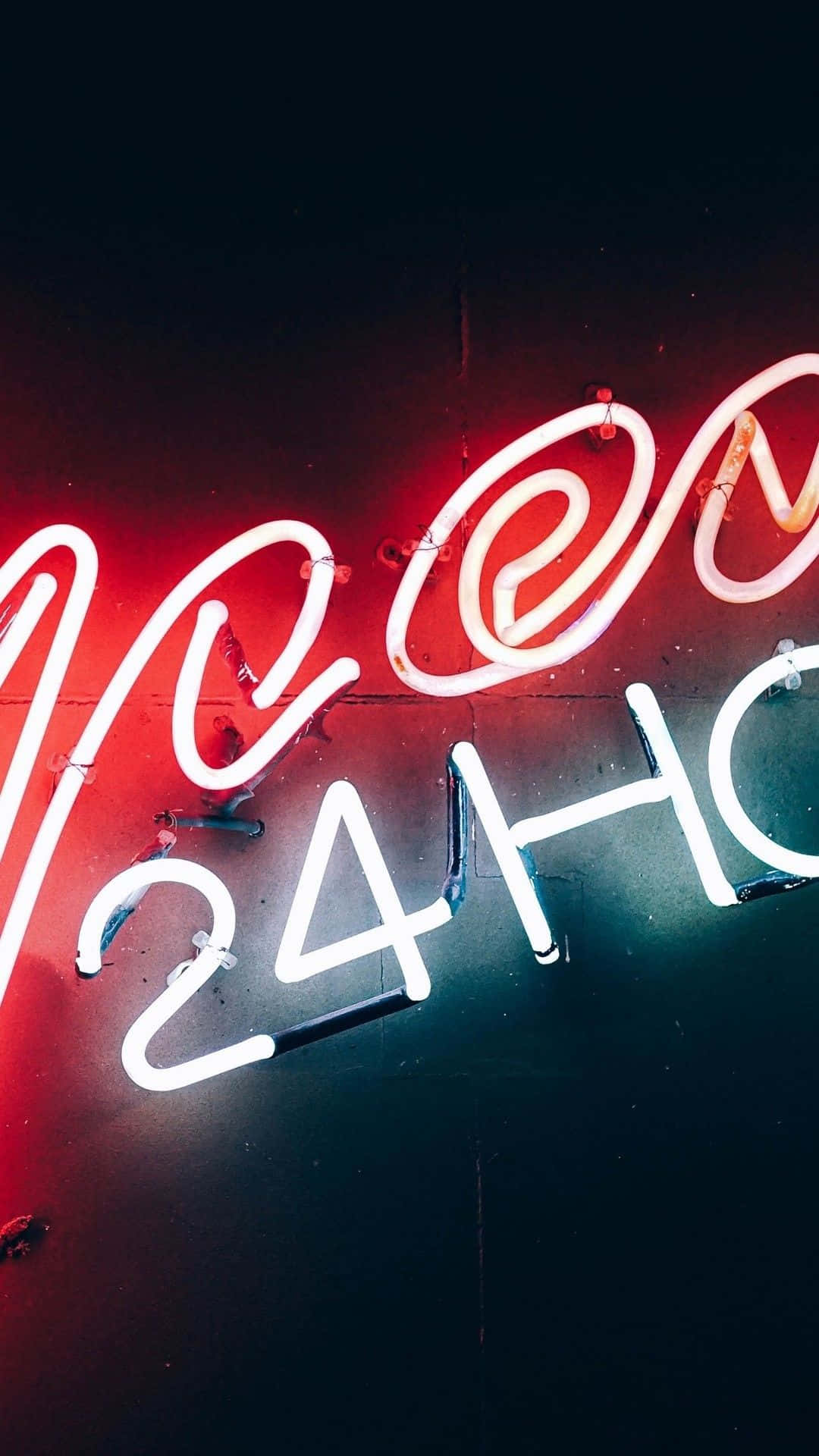 霓虹燈招牌，上面寫著 'NEON 24H'，在夜間的黑暗牆壁上發出紅色和白色的光芒。