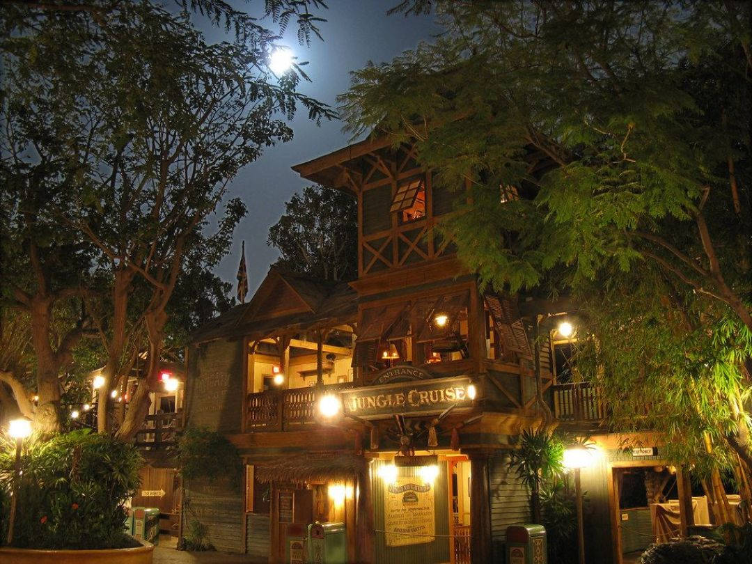 《叢林奇航》日出獵豹早餐 壁紙 — 在明亮的滿月下，夜晚溫暖照明的叢林遊獵小屋，周圍環繞著茂密的樹木。