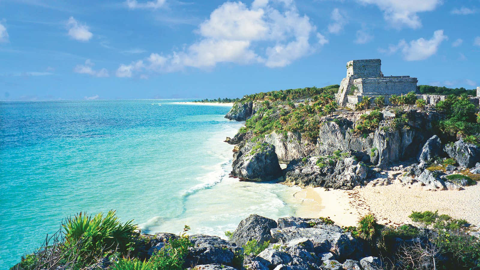 Mexican Beach 桌布 壁紙 — 古代瑪雅遺址戲劇性地棲息在岩石懸崖上，俯瞰著碧綠的海水和沙灘，天空湛藍明亮。