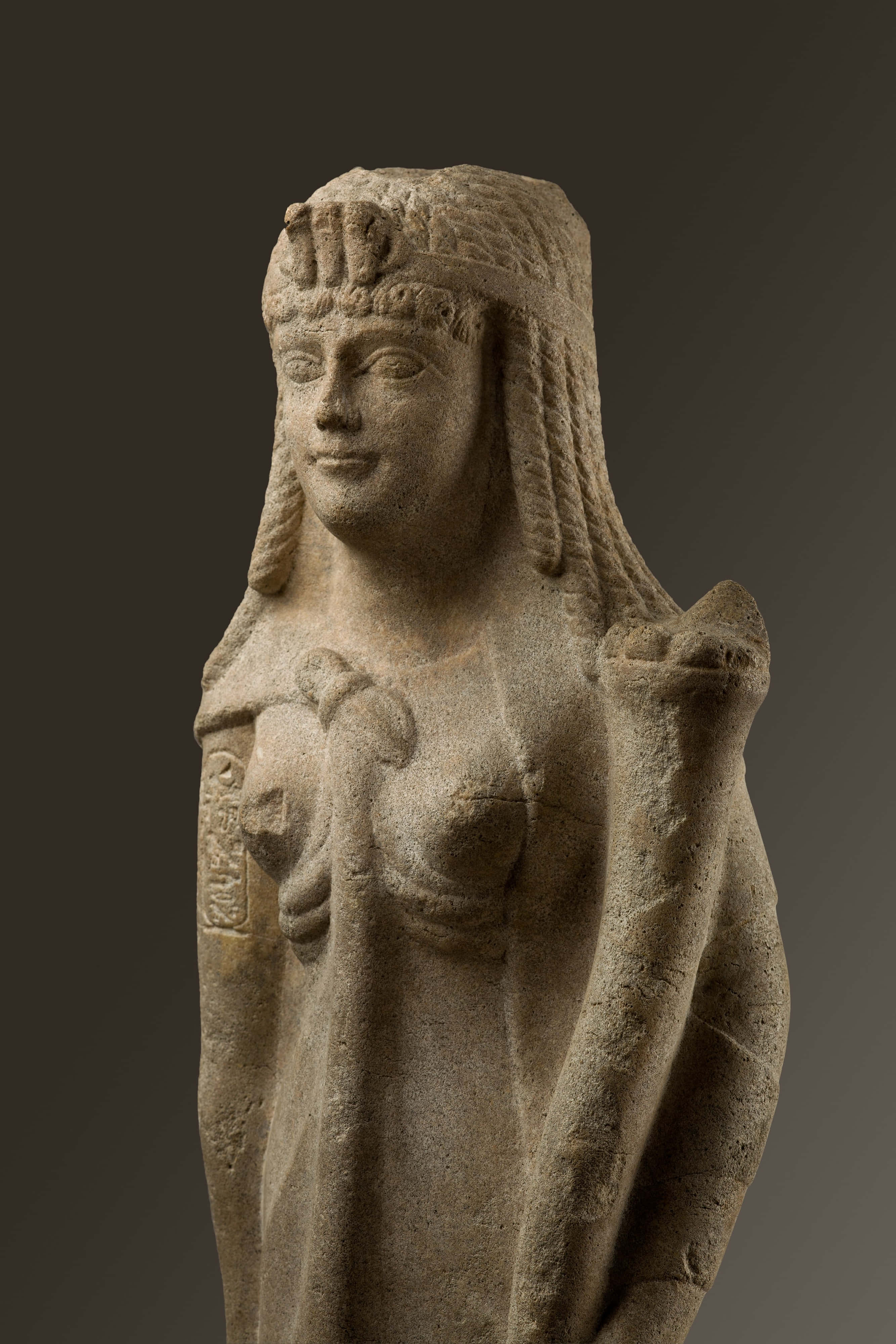 Cleopatra 桌布 壁紙 — 古代石像，一位寧靜的女性形象，編織頭髮並戴著頭飾，背景為深色漸變。