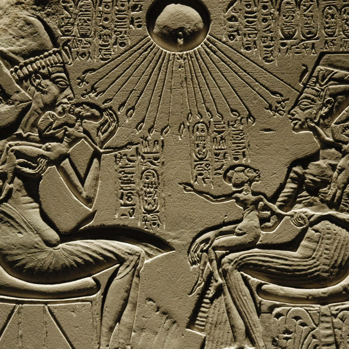 Ancient Egypt 桌布 壁紙 — 古代石浮雕雕刻描繪了兩個坐著的人物，位於帶有光線的太陽圓盤下，周圍環繞著象形文字。