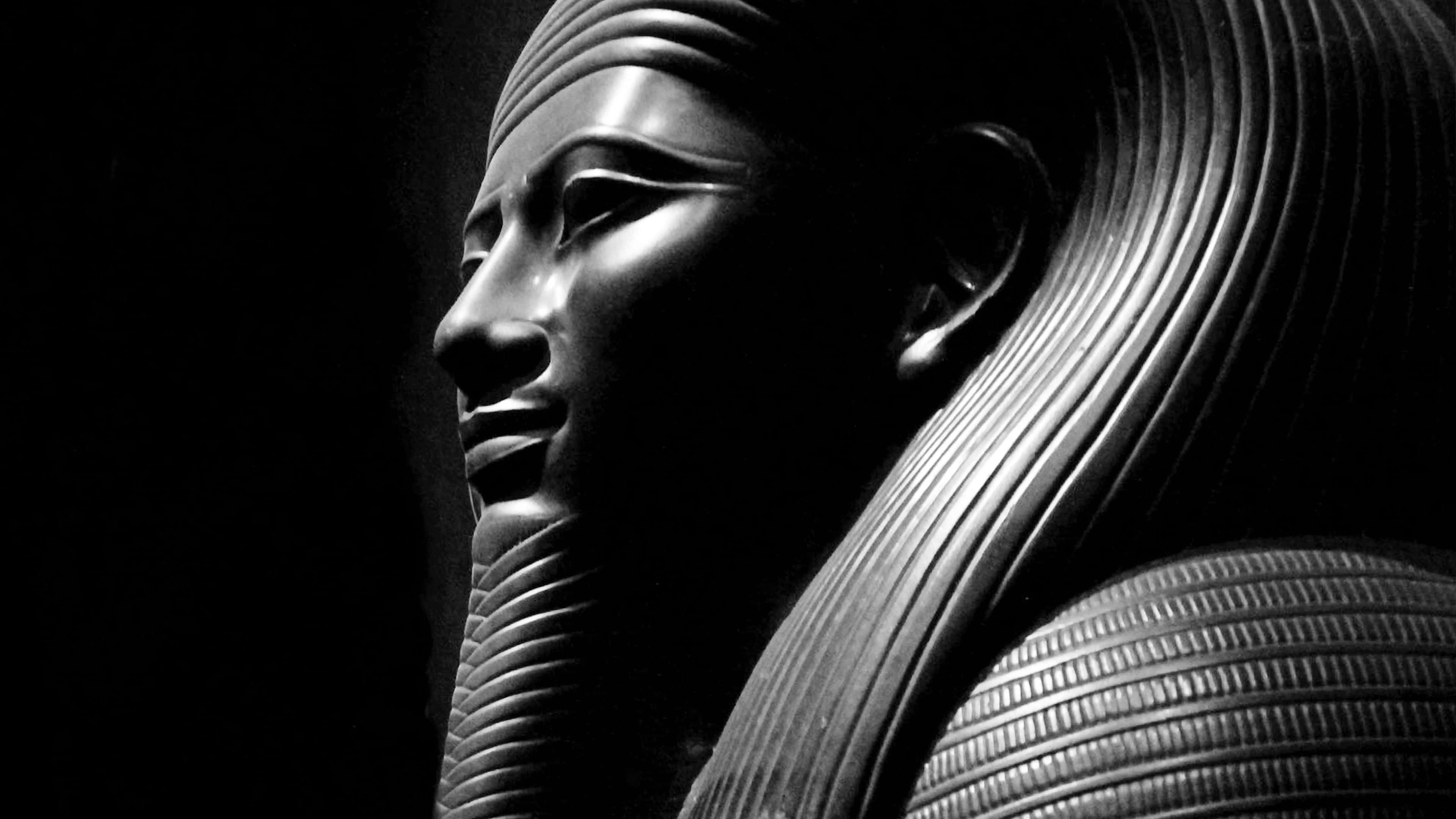 Ancient Egypt 桌布 壁紙 — 古埃及法老王雕像的戲劇性黑白特寫，帶有複雜的頭飾細節和強烈的明暗對比光線。