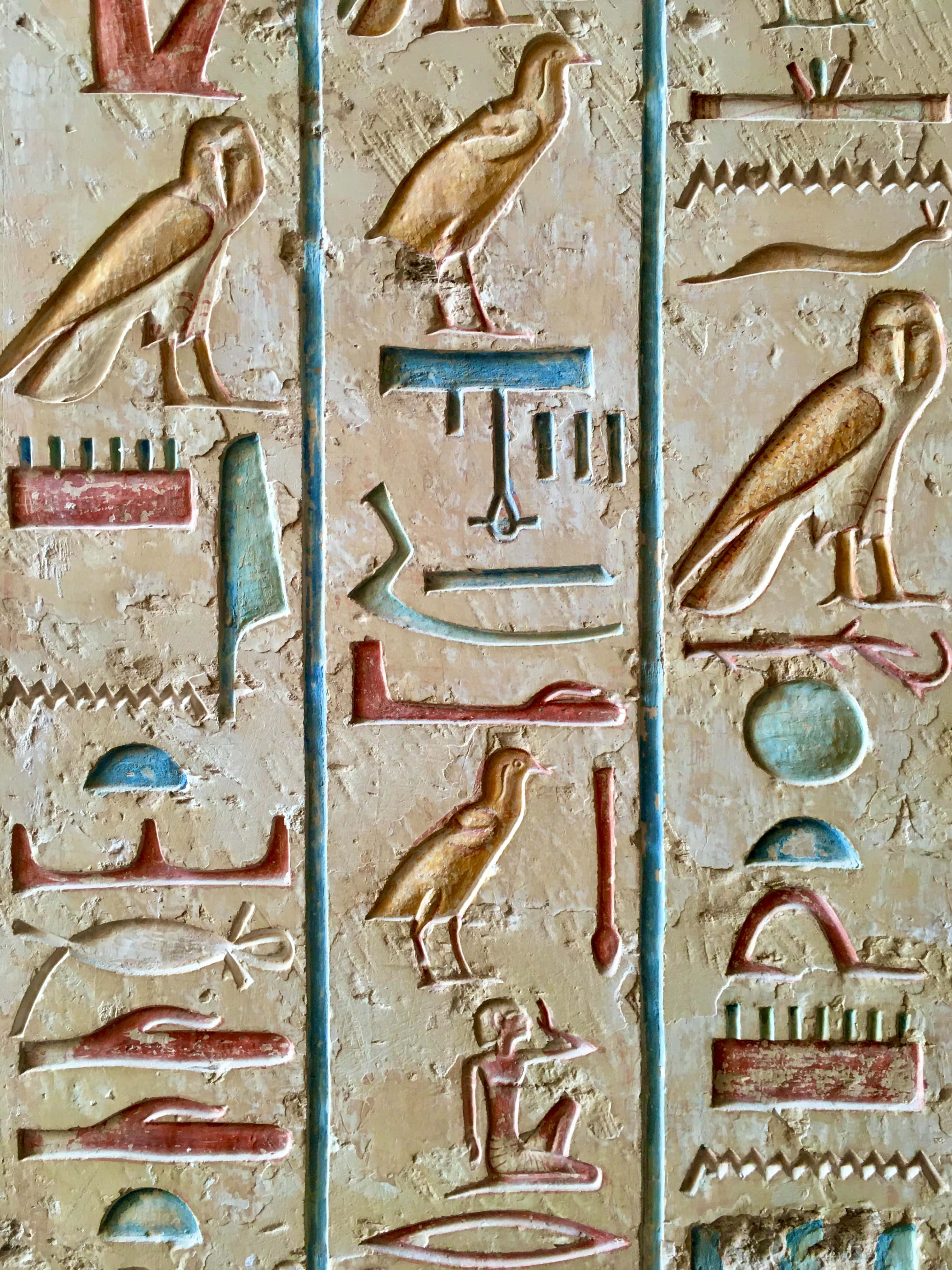 Ancient Egypt 桌布 壁紙 — 古埃及象形文字的特寫，雕刻在風化的石頭上，帶有褪色的紅色、藍色和金色顏料。