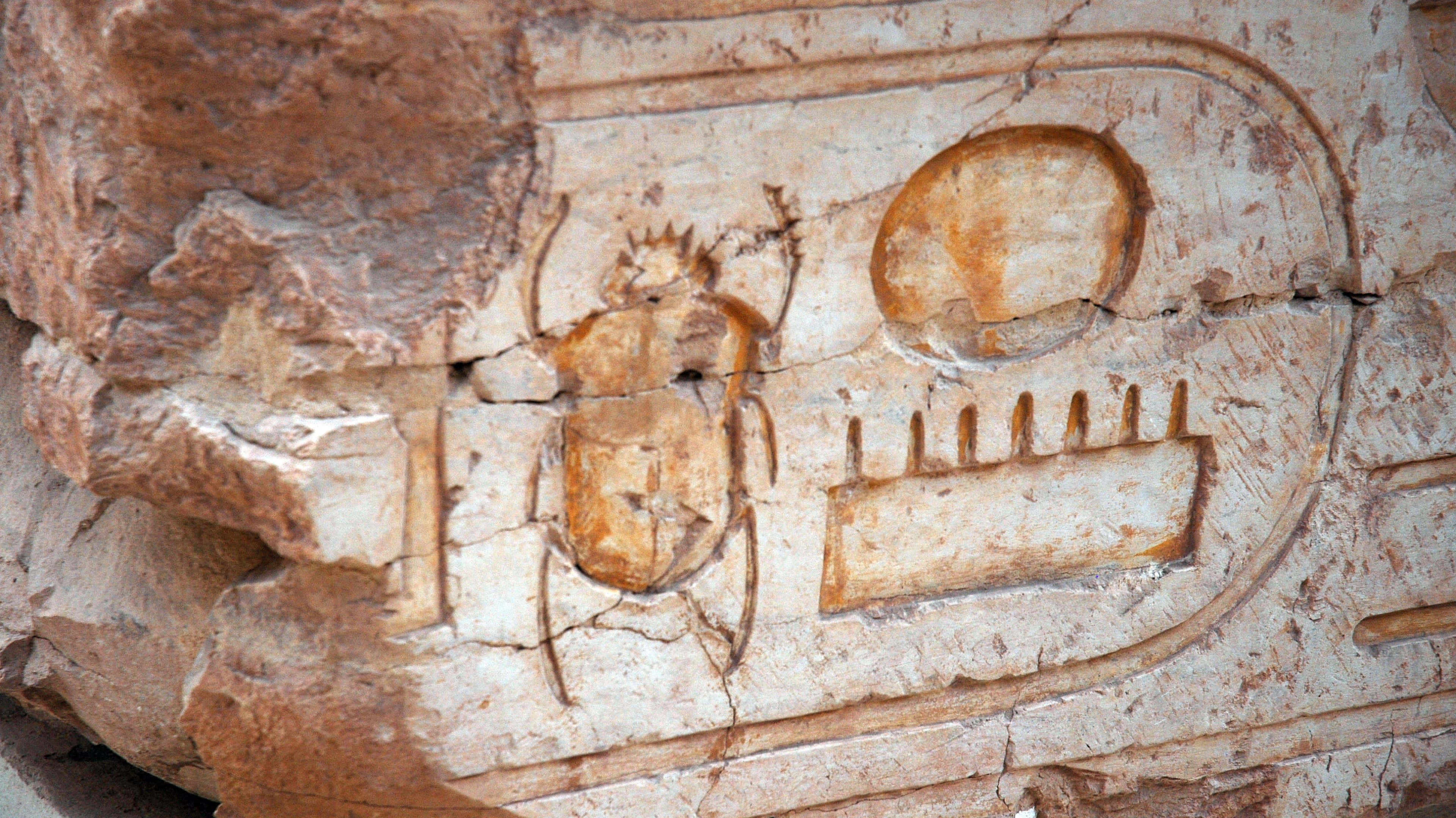 Ancient Egypt 桌布 壁紙 — 古埃及雕刻聖甲蟲和太陽圓盤符號，位於風化的石牆上。