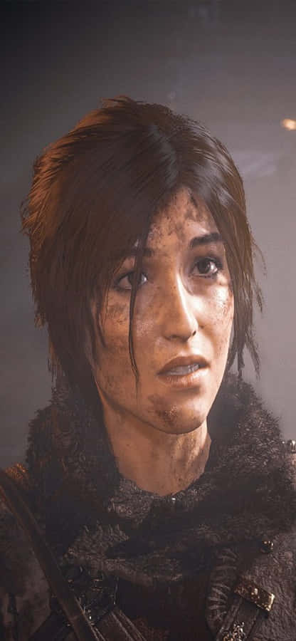 古墓麗影 - PS4 壁紙 — 一個特寫鏡頭，捕捉一位決心堅定的女性，她臉部骯髒、棕色頭髮凌亂，身穿毛領大衣，處於昏暗燈光下。