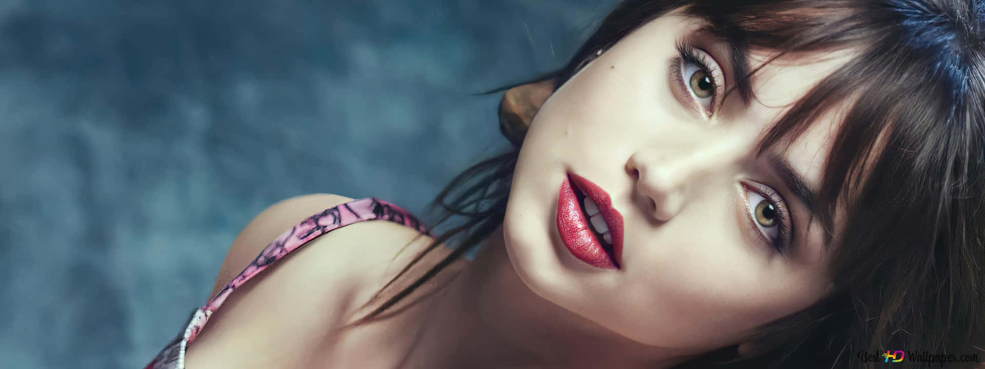 一位擁有紅唇和深色頭髮的女性在攝影棚環境中看著相機。