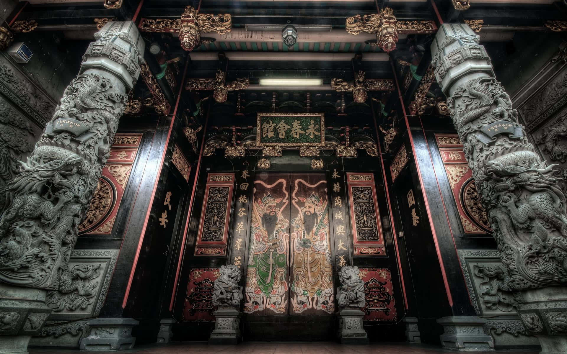 古廟建築之美 壁紙 — 宏偉的傳統寺廟內部，有精雕細刻的龍柱和華麗的彩繪門，在戲劇性的燈光下。