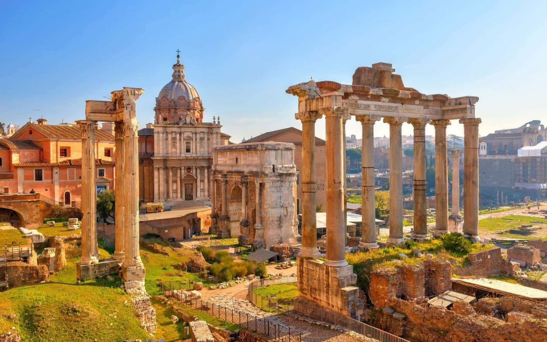 Rome 桌布 壁紙 — 古羅馬遺跡，有高聳的柱子和圓頂教堂，在清澈的藍天下。