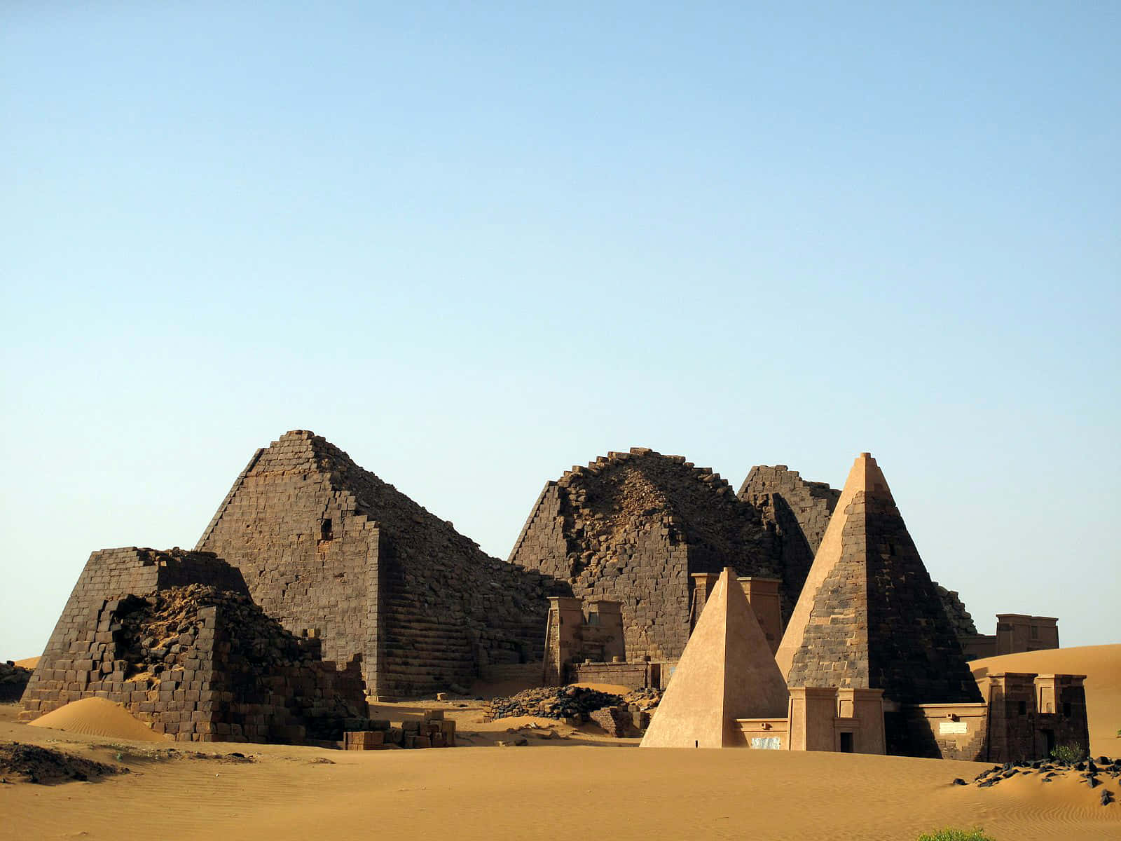 Ancient Egypt 桌布 壁紙 — 古老嘅石造金字塔喺廣闊嘅金色沙漠中，喺晴朗嘅藍天下，顯得風化而宏偉。