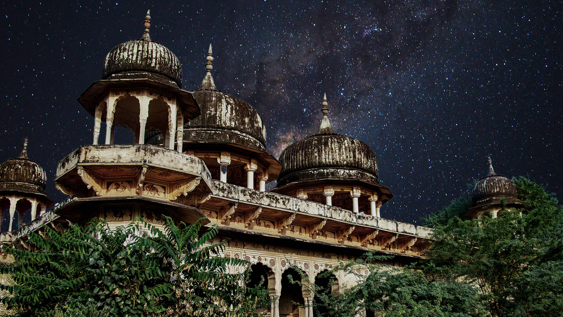 India 桌布 壁紙 — 古老圓頂寺廟群，星空下可見銀河拱橋橫跨天際。