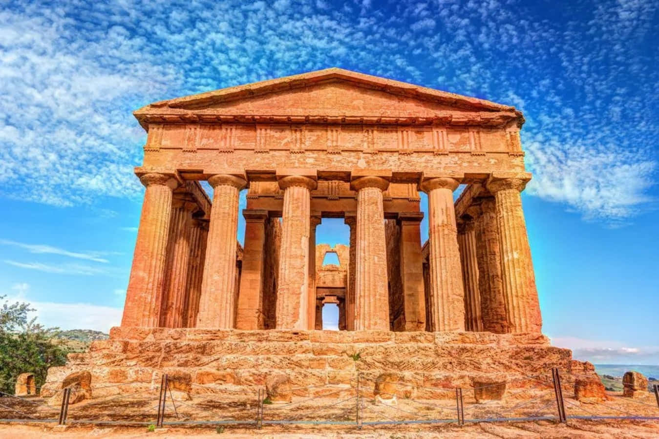 greek 桌布 壁紙 — 古老寺廟擁有高聳的柱子，在點綴著縷縷白雲的鮮豔藍天下巍然矗立。