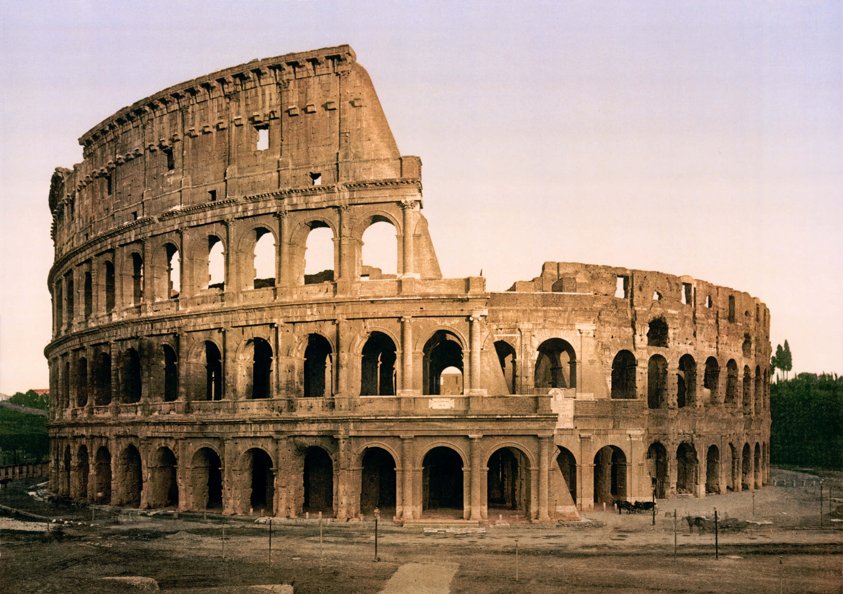 Roman 桌布 壁紙 — 古老的羅馬鬥獸場在羅馬雄偉地矗立，其標誌性的拱門和風化的石頭在柔和天空下展現。