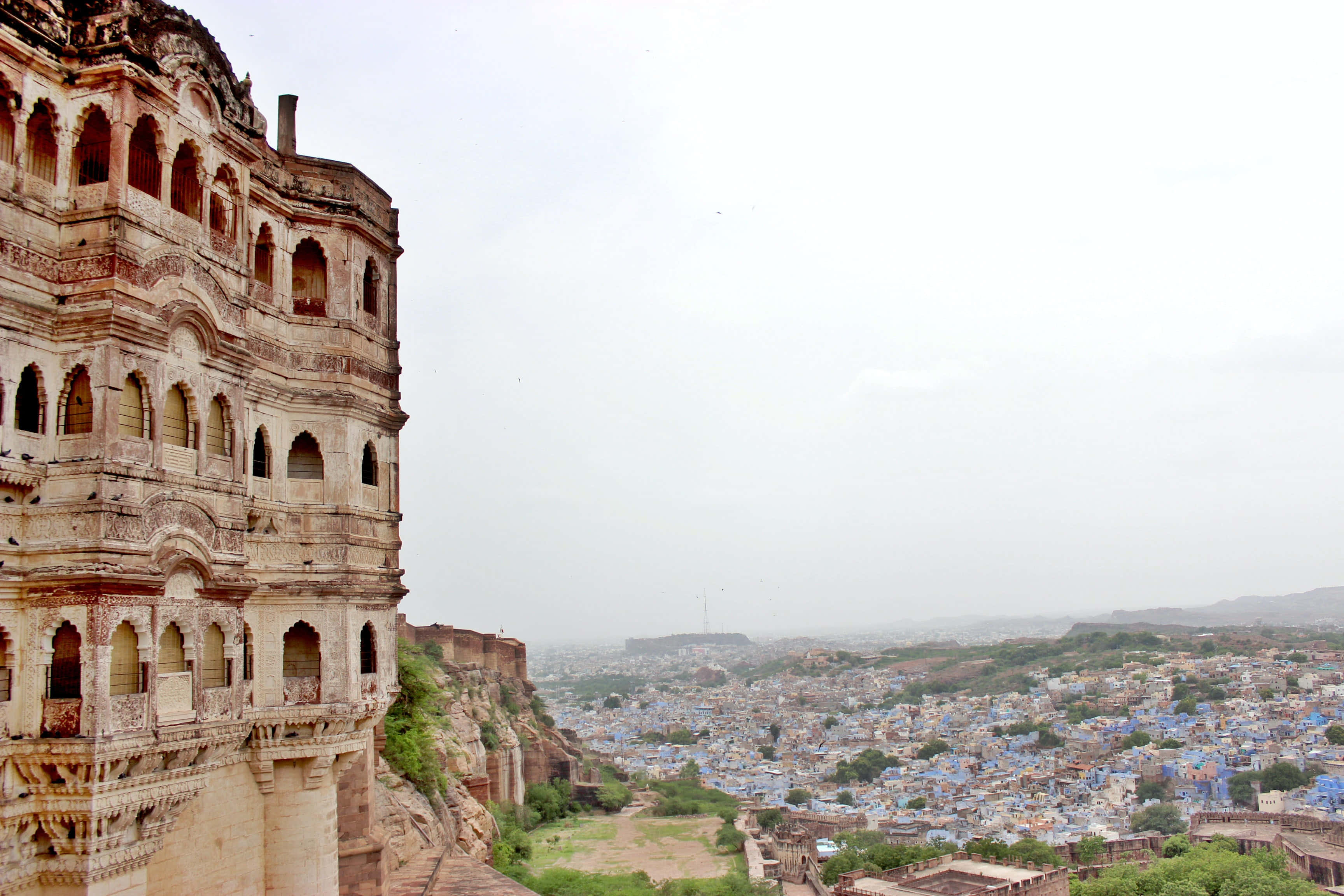 Rajasthan 桌布 壁紙 — 古老石堡俯瞰著一座坐落在霧氣繚繞山丘中的藍牆城市。