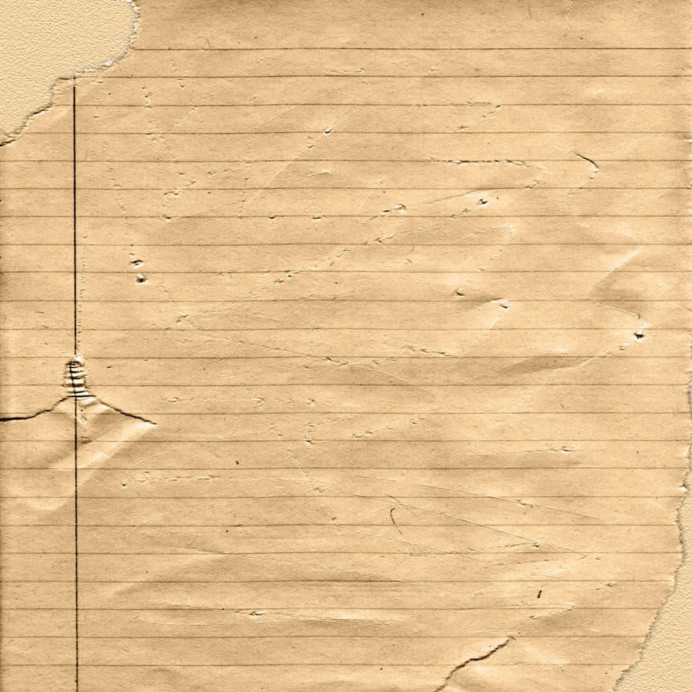 古舊紙張上的手寫筆記 壁紙 — 舊米色橫線筆記本紙張的特寫，邊緣破損，帶有微弱的摺痕，顯示其磨損的質感。