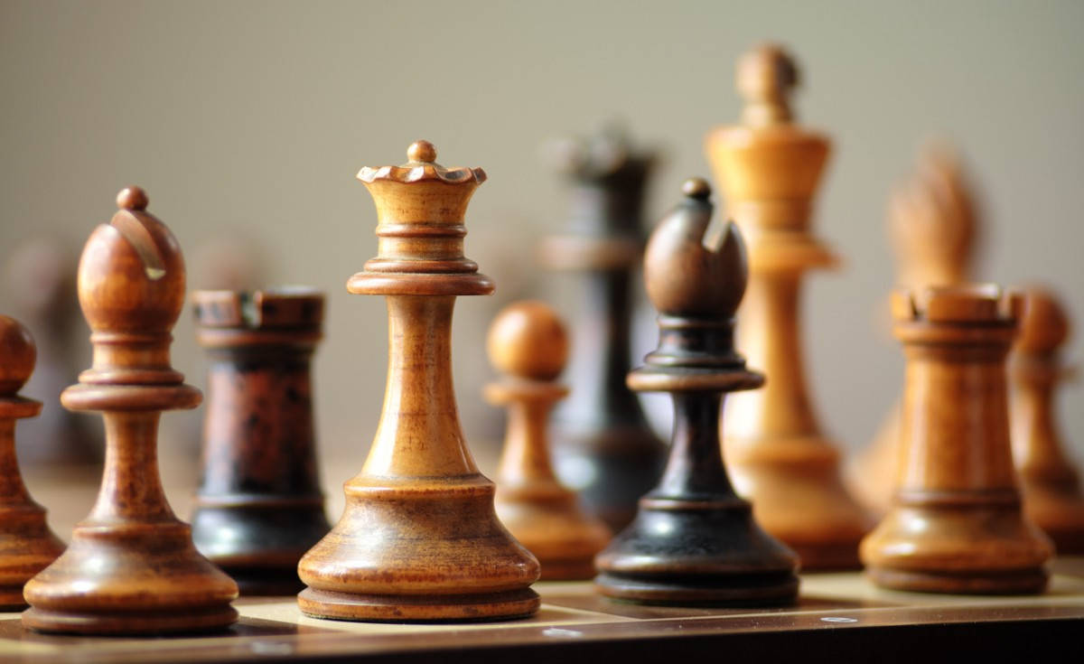 木製國際象棋棋子喺棋盤上排列，淺景深。