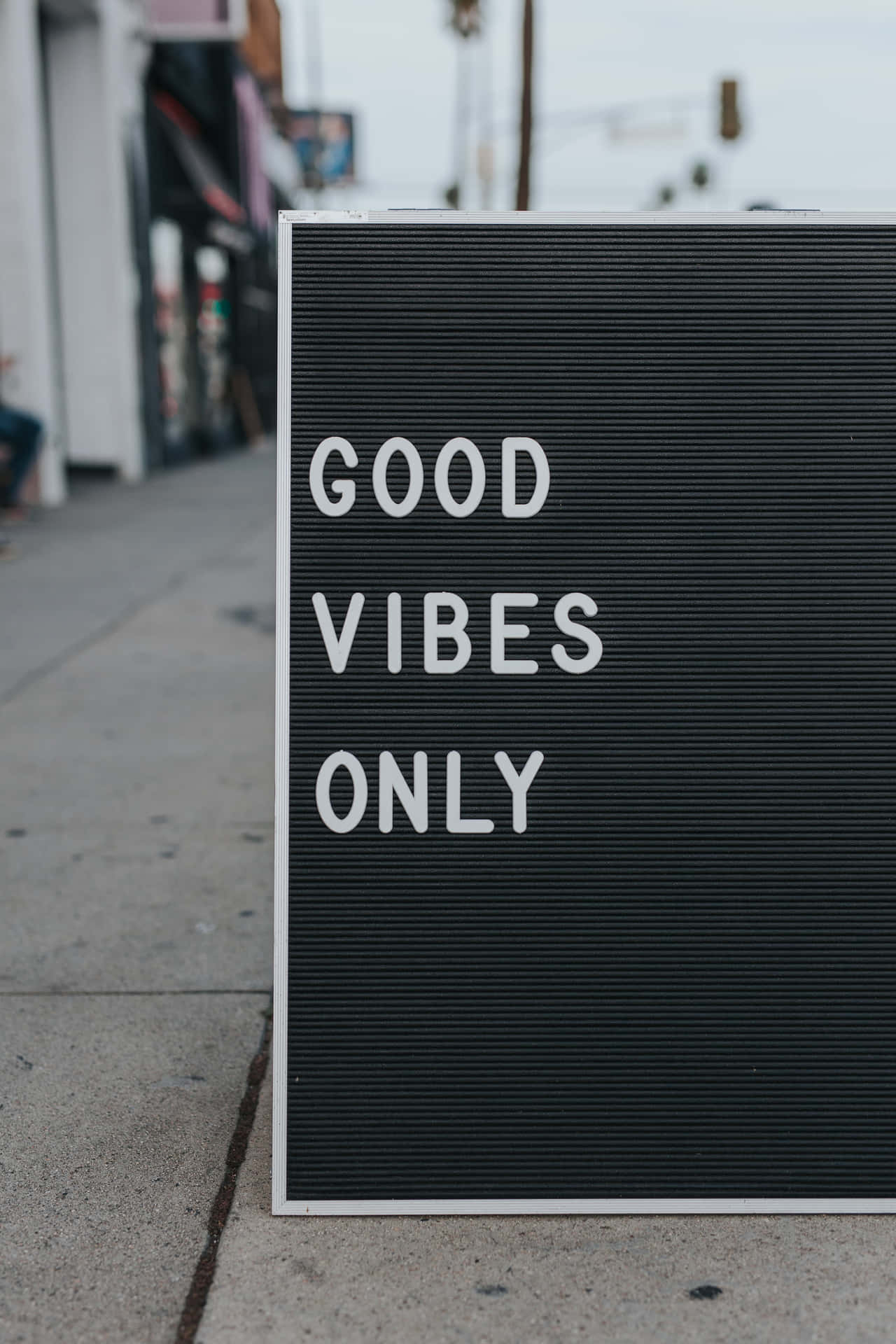 城市行人路上寫有「GOOD VIBES ONLY」的黑色字母板。