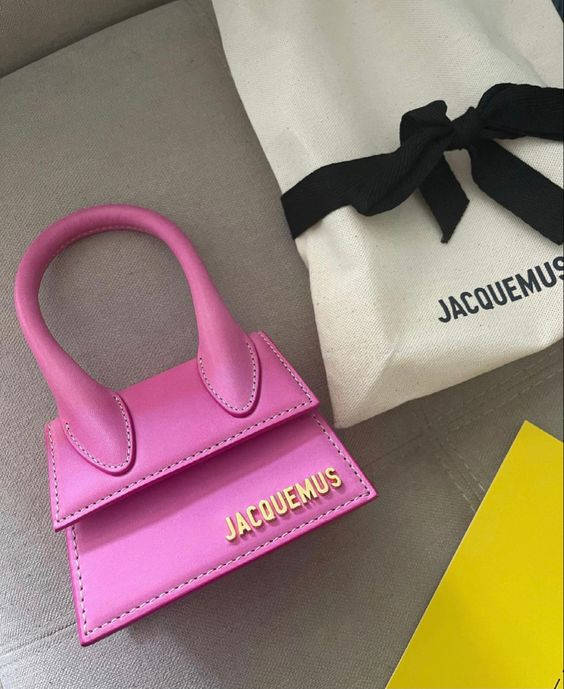 粉紅色Jacquemus手袋，金色標誌，旁邊是品牌防塵袋。