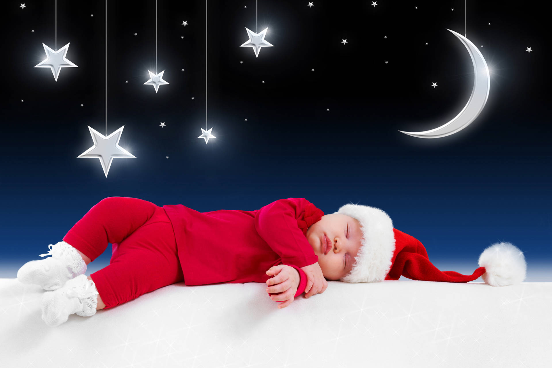 穿著紅色聖誕老人服裝的嬰兒在星星和月亮下的雪地上睡覺