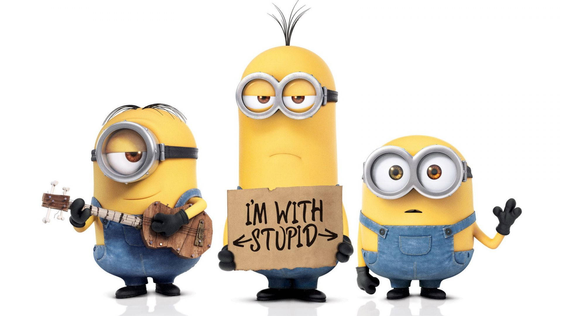 三個Minions，一個彈奏烏克麗麗，一個舉著寫有I'M WITH STUPID的牌子