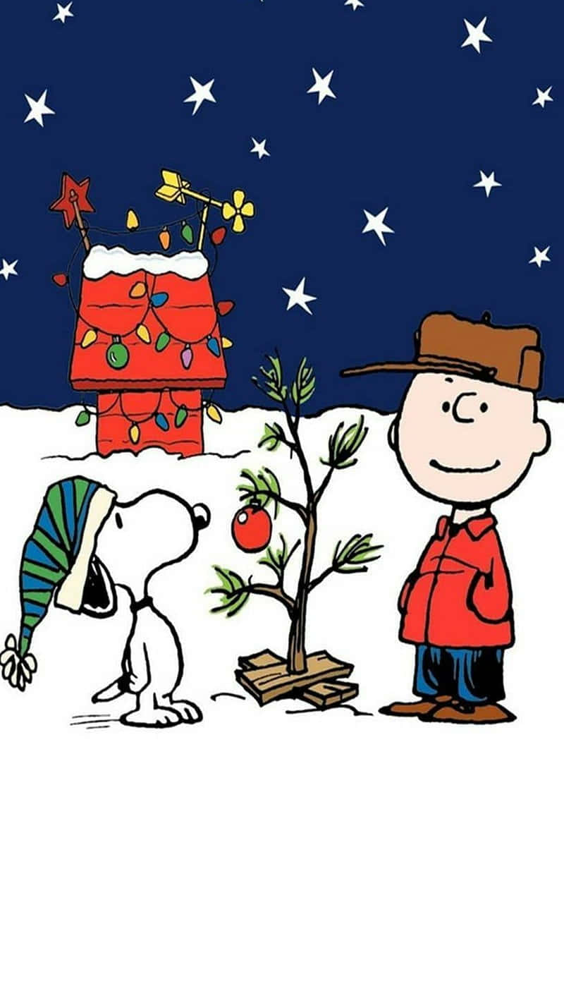 查理布朗和史努比在星空下看著雪地裡的一棵小聖誕樹。