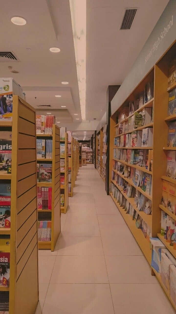 明亮的長書店通道，木製書架上擺滿書籍，上方有天花板燈光。