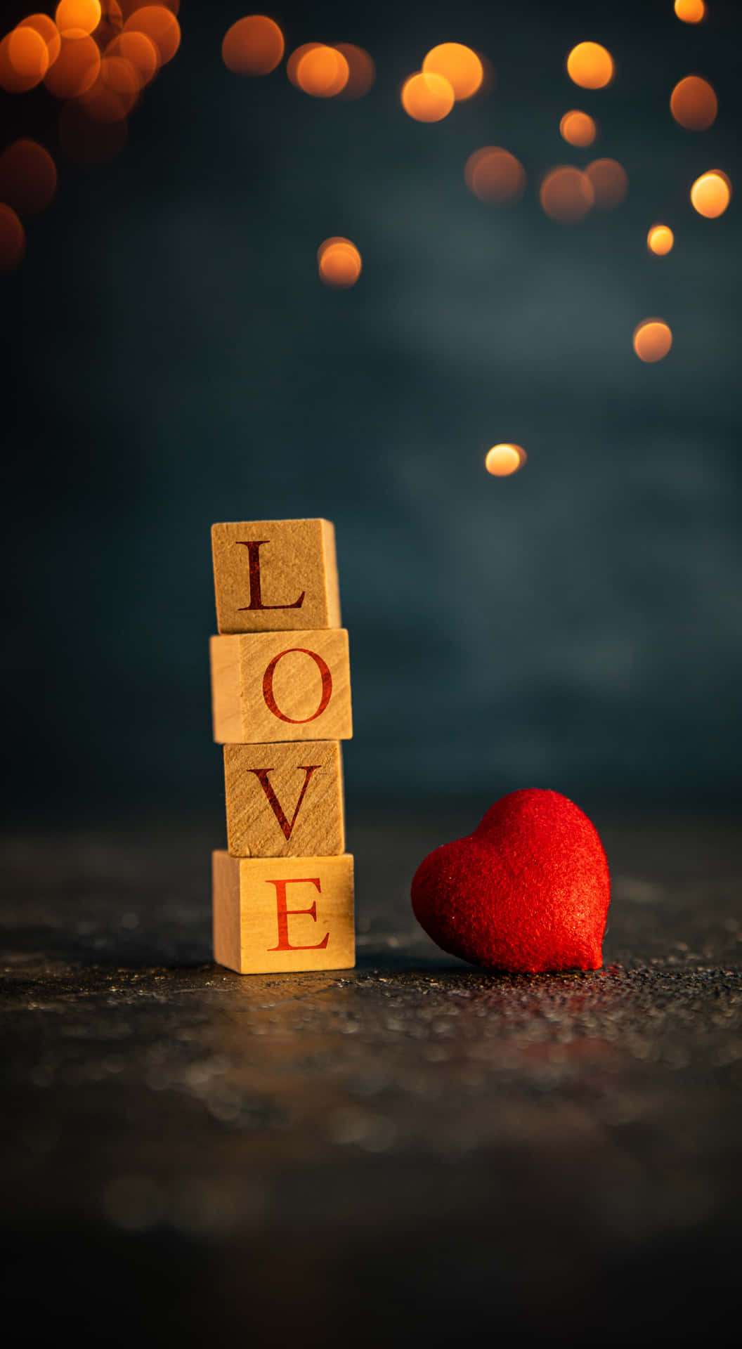 拼出 LOVE 的木製方塊，旁邊有一個紅色心形，背景有發光的燈光。