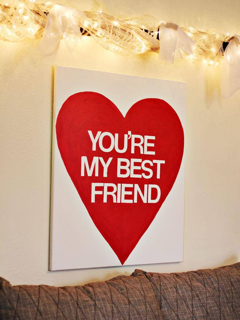 紅色心形畫布，白色文字「You're My Best Friend」，掛在串燈下。