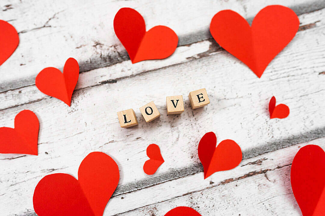 可愛愛心木板上的愛 壁紙 — 紅色紙心心及拼出 love 的木塊放在經風化的白色木質表面上。