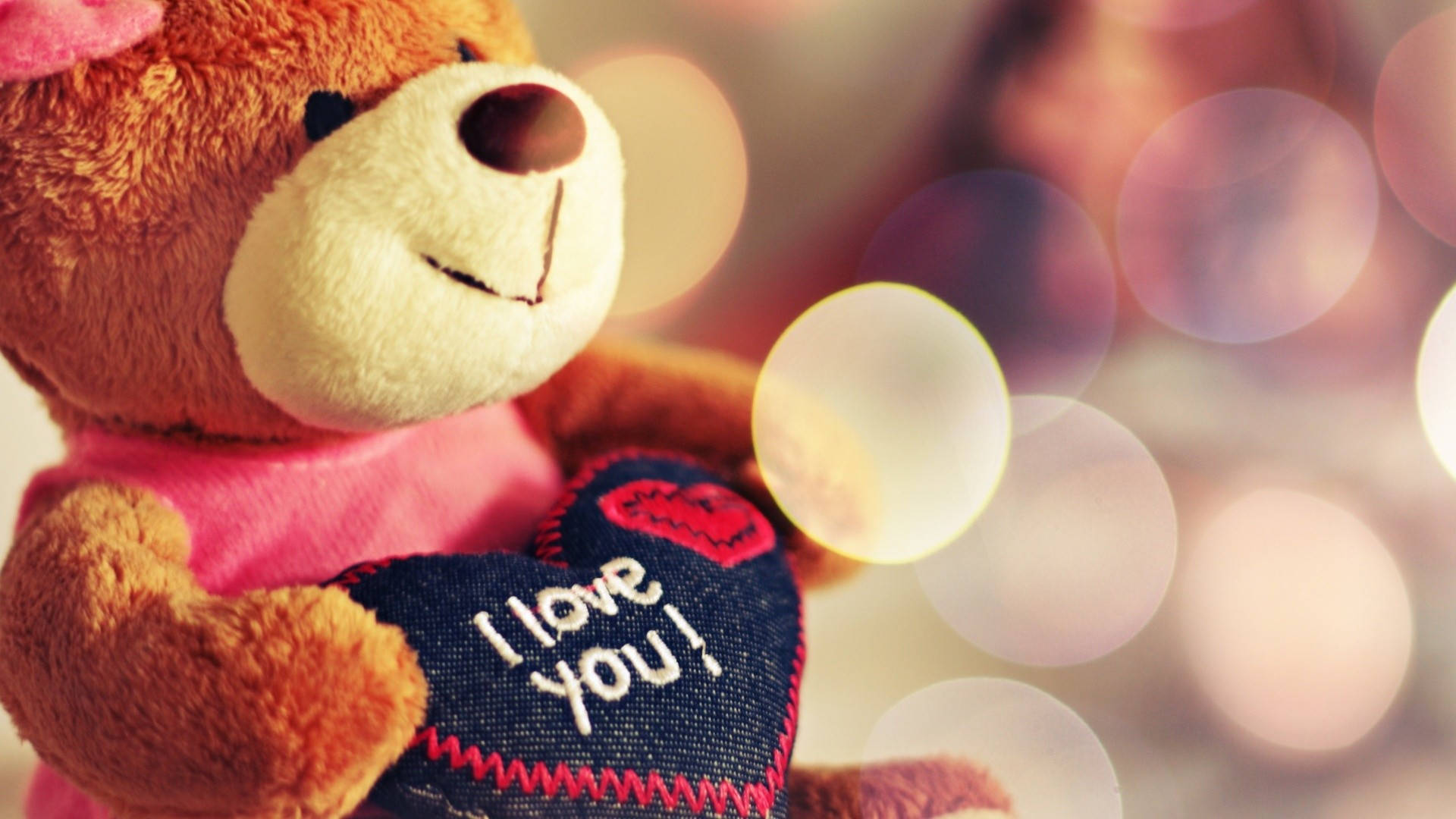 一隻泰迪熊拿著一個寫著I love you的心形