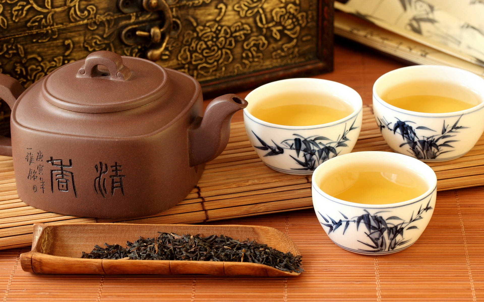 傳統中式茶具，杯子和茶壺有竹紋設計，放在竹蓆上。