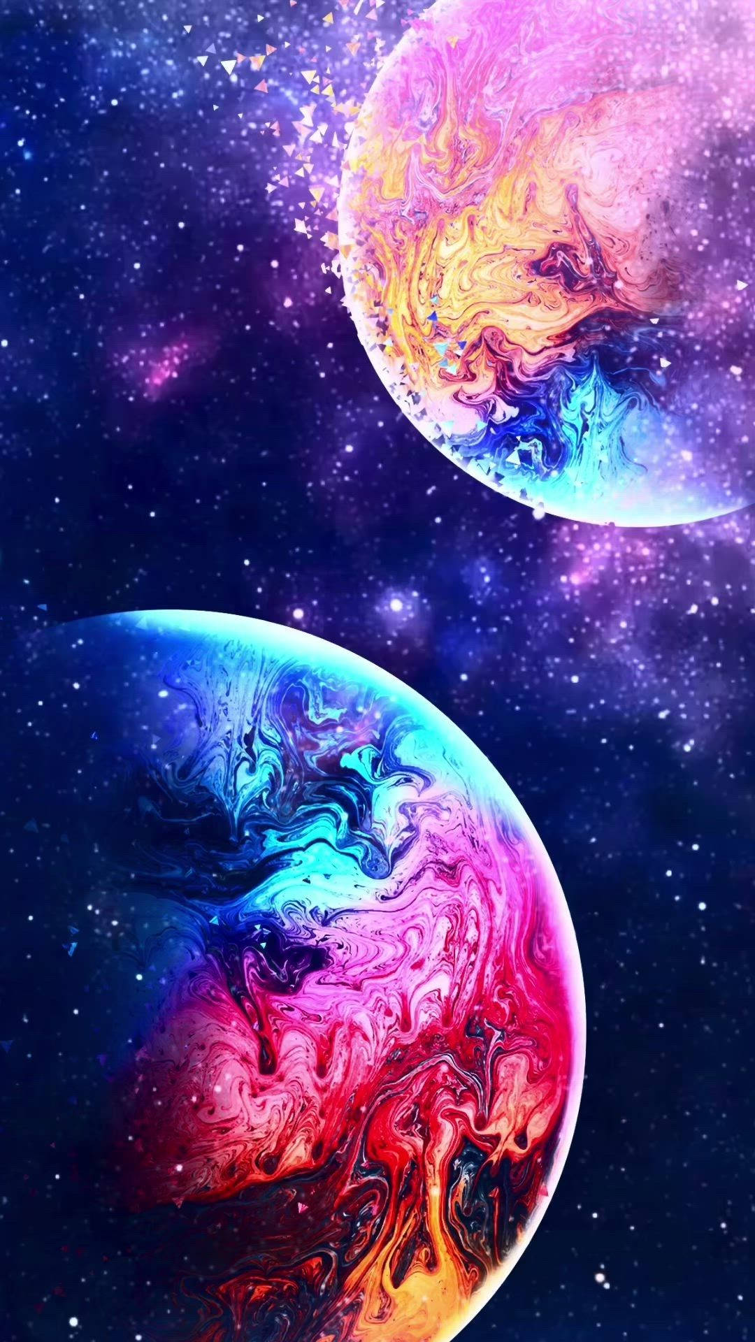 可愛星系中碰撞的雙行星 壁紙 — 兩顆旋轉的彩色行星漂浮在繁星點點的宇宙虛空中，伴隨著充滿活力的星雲和發光的粒子。