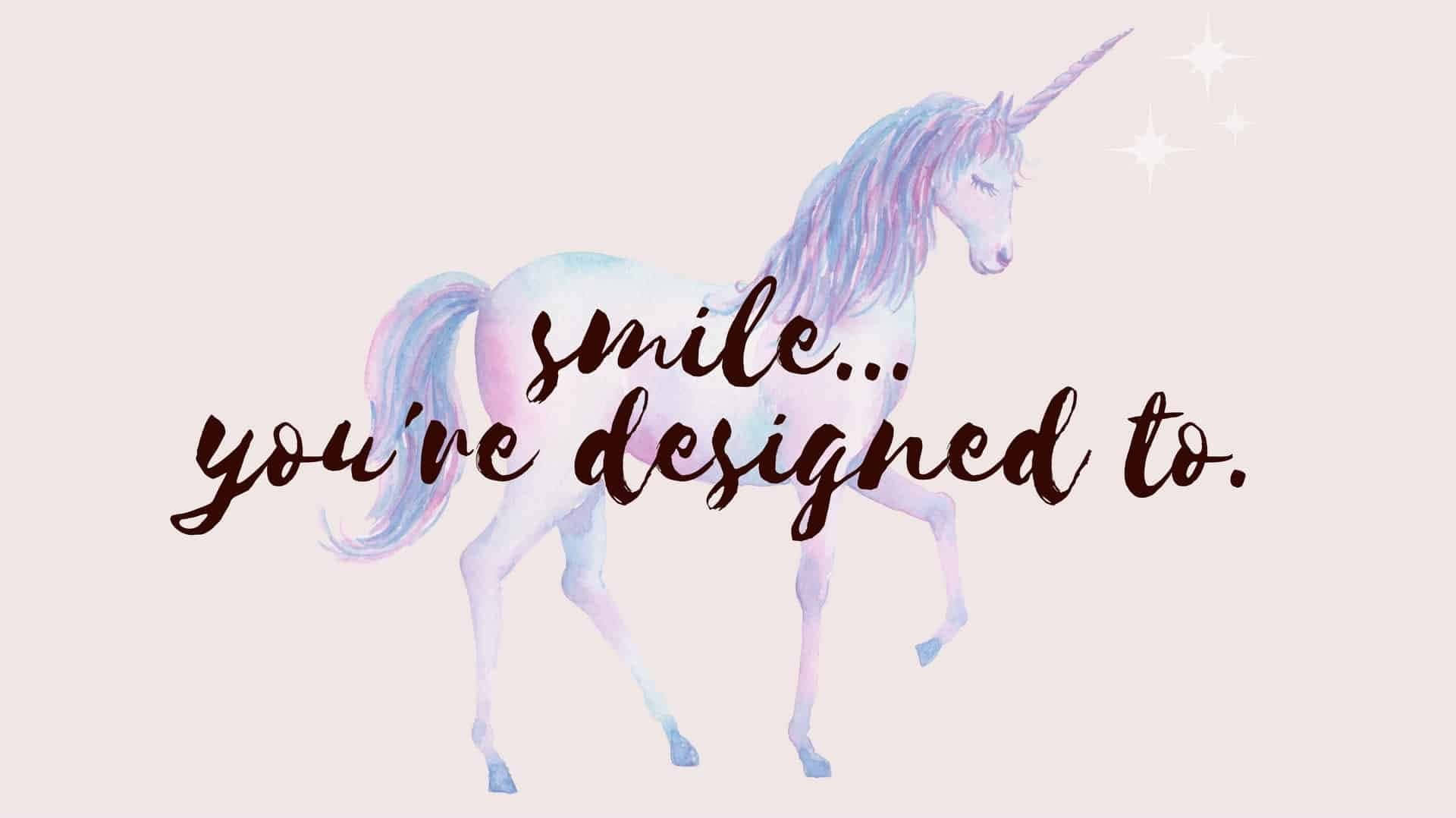 一隻粉彩水彩獨角獸，帶有「smile you're designed to」字句。