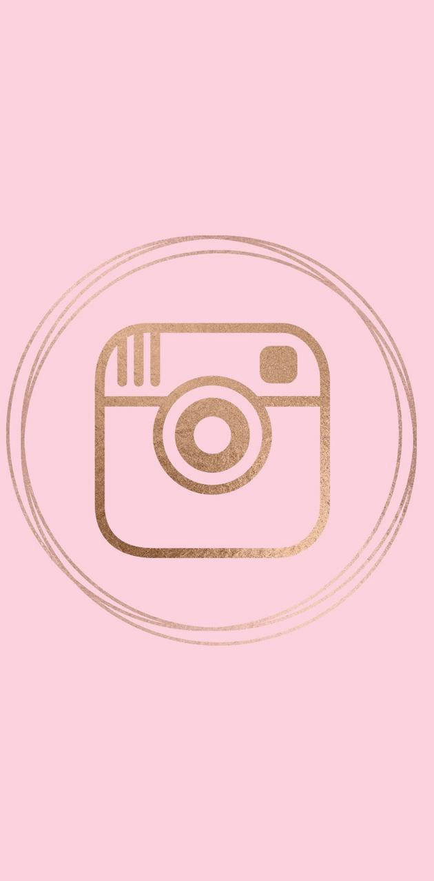 可愛的Instagram標誌在粉紅色背景上 壁紙 — 一個極簡金色閃粉Instagram標誌，居中於雙圓圈內，背景為柔和粉紅色。